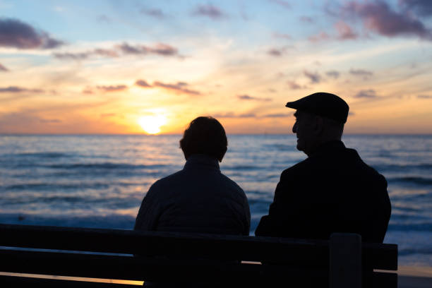 La Jolla, CA: Senior Couple on Bench Windansea Beach Sunset stock photo