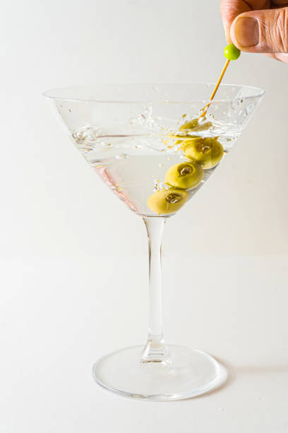 istock martini glass with olives in vertical orientation with white background. 1364832622