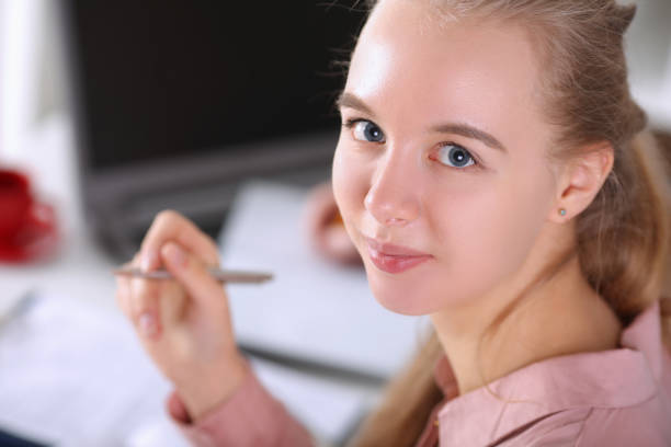 istock Cute woman writing report 1364835983