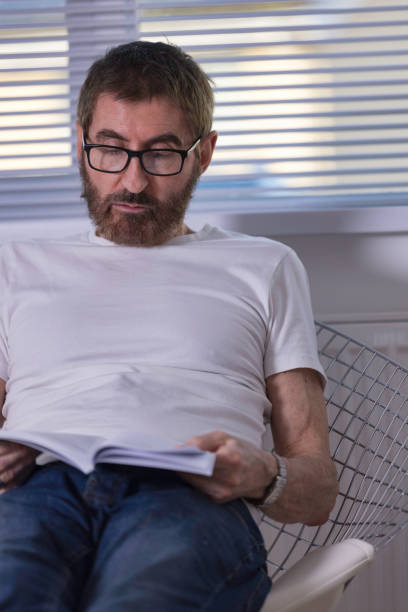 istock Senior man reading at home 1364837233