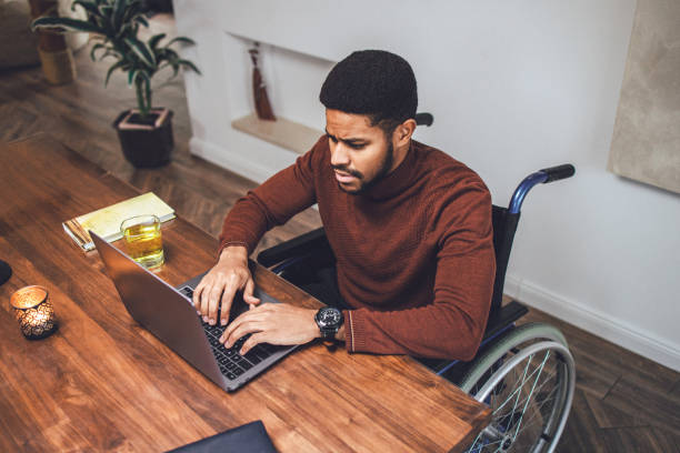 istock Disabled young African-American male working at home 1364837936