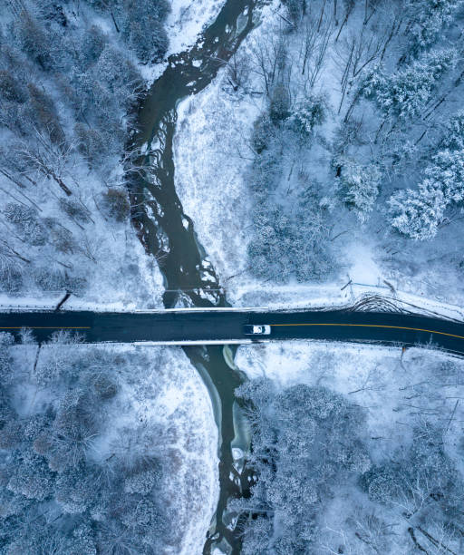 雪が降った後、森の中を運転している車、カナダ - vertical scenics ice canada ストックフォトと画像