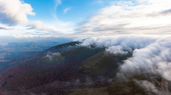 Thick layer of white clouds above road on mountain ridge