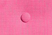 Home upholstered furniture concept. Pink fabric background. Three round ornament detail.