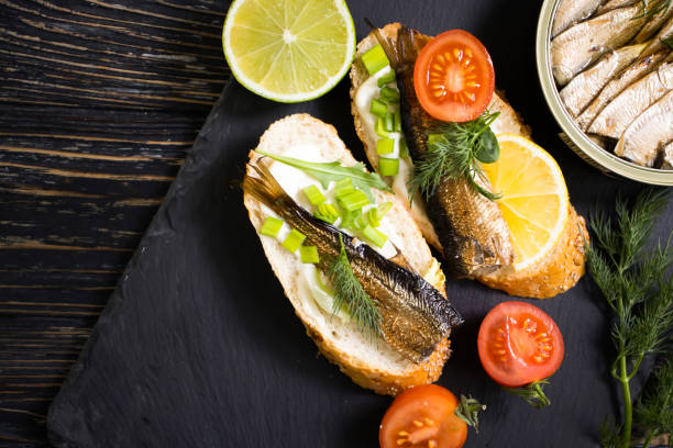 istock sprats in a can, fresh dill on wooden background 1364841910