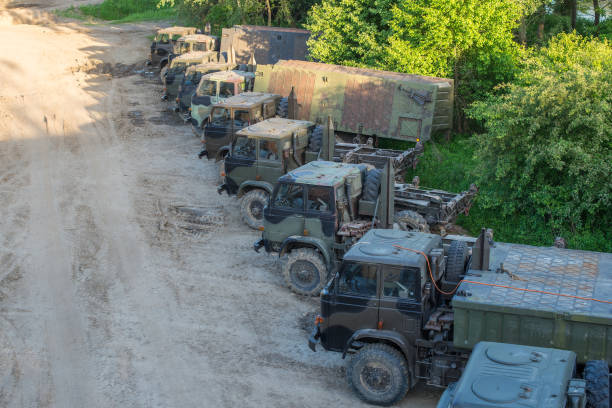 Military transportation troop trucks parked in a row on a battlefield