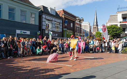 Almelo, Twente, Overijssel, Netherlands, september 22nd 2012, large group of audience sitting and standing side by side to watch a (free) outdoor act of US clown Rob Torres (1973-2018) on a sunny day at a town square in the downtown area of Almelo