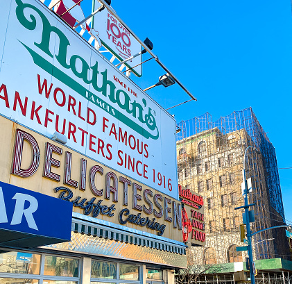 Brooklyn, New York, United States - January 8, 2022: The original Nathan's Famous hot dog restaurant location at the corner of Surf and Stillwell Avenues in the Coney Island area of Brooklyn, New York City.  Established 1916.