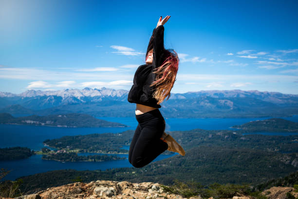 молодая девушка прыгает на вершине горы - south america argentina bariloche autumn стоковые фото и изображения