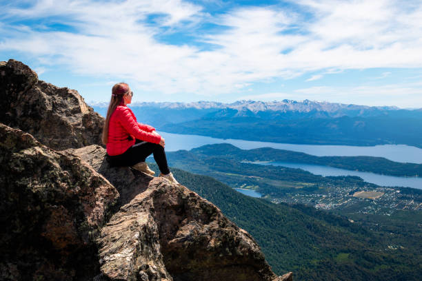 молодая девушка сидит на вершине горы - south america argentina bariloche autumn стоковые фото и изображения