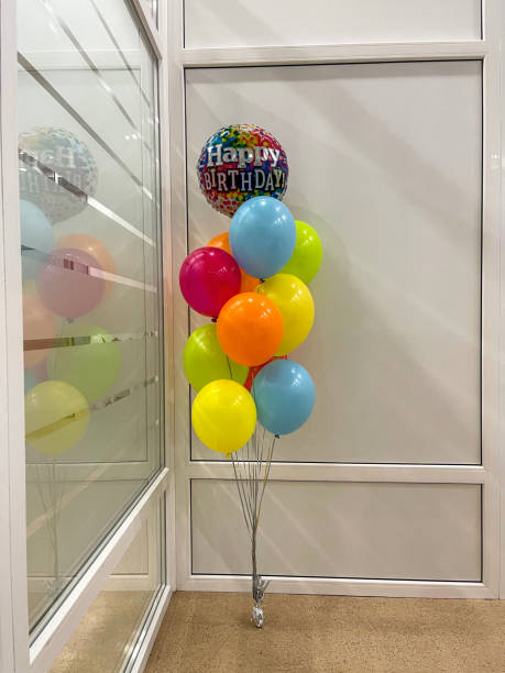 istock Colored helium balloons with Happy birthday balloon on white wall background 1364852643