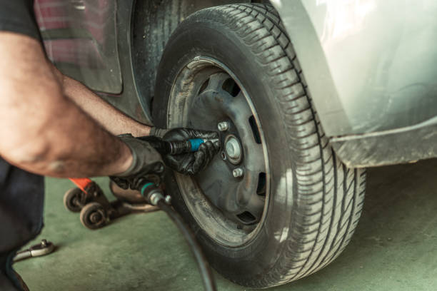 istock Man using an electric screwdriver to remove a wheel in a garage 1364854440
