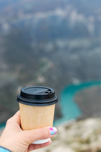 istock A young woman holding disposable coffee cup 1364855483