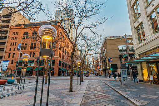 Wide Angle Shot of 16th Street Mall Downtown Denver on a Winter Evening Featuring the Iconic Light Posts\n\n16th Street is a Popular Tourist Shopping Destination Outdoor Mall Closed to Traffic with Public Transport, Local Shops, Art, and Music.