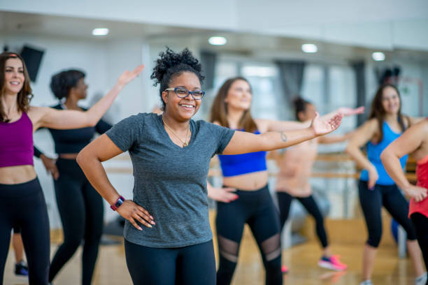 Dancing for fitness A diverse group dance along to the music together in an exercise dance class. Zumba stock pictures, royalty-free photos & images