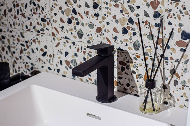 robinet noir sur le lavabo de la salle de bain, le mur est décoré de carreaux de style terrazzo - toughness endurance built structure architectural styles photos et images de collection