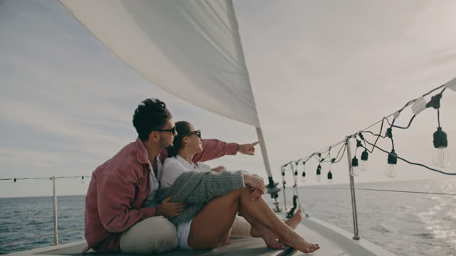 SLO MO Wealthy young couple relaxing on a deck of a sailboat