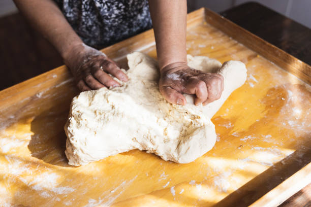 istock Old woman's hands kneading bread dough. Empanadas. Wooden table. Ethnical food 1364870695