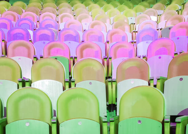 Empty seats in the auditorium, neon green and pink light.
