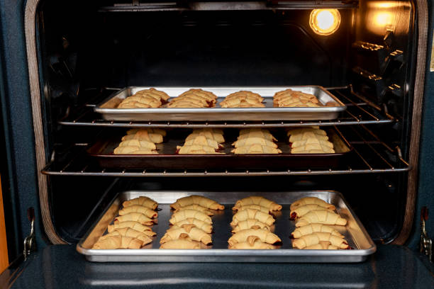 istock Oven tray with baked crescent cookies in oven. 1364876799