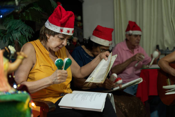 노베나스 기간 동안 크리스마스 캐롤을 부르는 손자와 조부모의 가족 - caroler 뉴스 사진 이미지