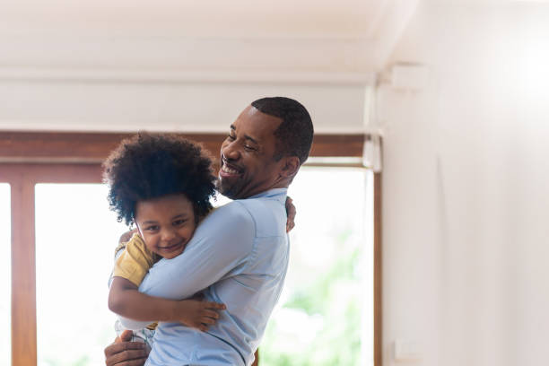 彼のかわいい愛する小さな息子を保持している笑顔のアフリカ系アメリカ人の父親。 - father fathers day baby child ストックフォトと画像