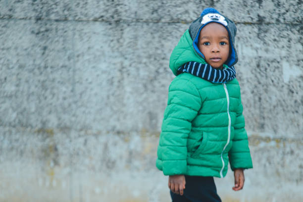 african american boy playing outdoors in winter african american kid wearing winter outfit outoors kids winter coat stock pictures, royalty-free photos & images