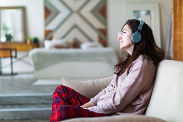 istock Young woman resting at home with music 1364898768