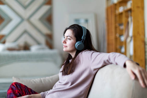 istock Young woman resting at home with music 1364899295