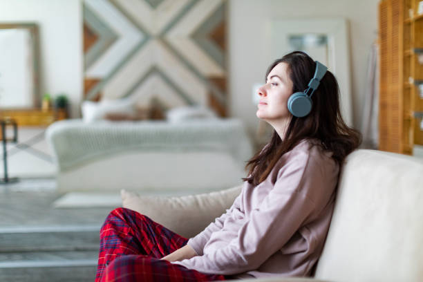 istock Young woman resting at home with music 1364899301