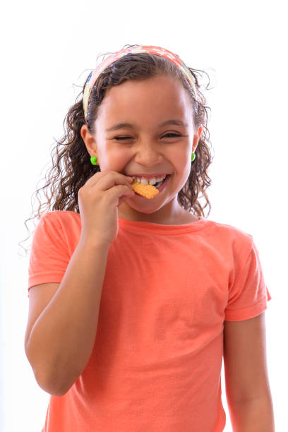 istock Happy Young Girl Eating Biscuit 1364899374
