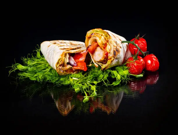Photo of Meat in pita bread with vegetables and herbs.