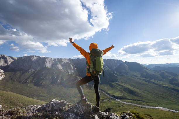 istock Successful woman backpacker hiking on alpine mountain peak 1364900593