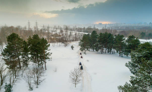istock People on ATVs in the forest in winter.