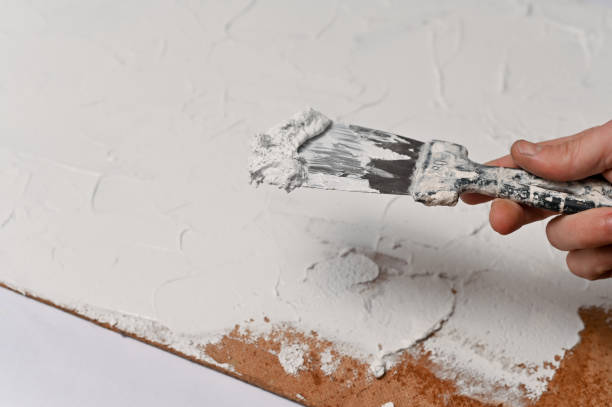 istock A spatula, the process of applying a layer of putty 1364904404
