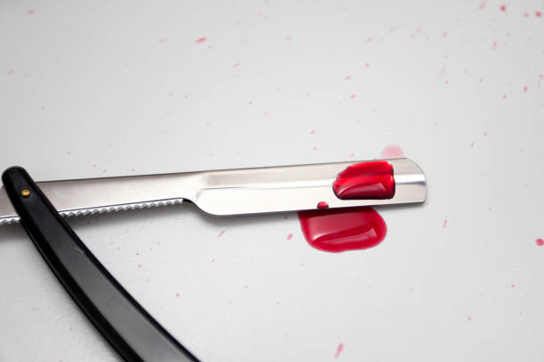 istock Drops of blood on a straight razor 1364905023