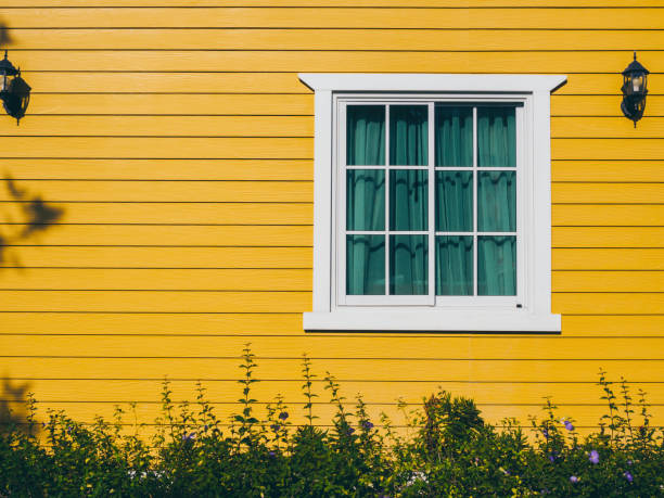 une fenêtre de maison blanche avec verre, décoration de rideau vert avec des appliques murales sur le résident en bois jaune, vue de l’extérieur. - close color photos et images de collection