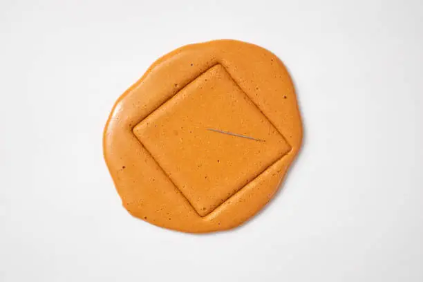 Photo of Korean Dalgona sugar candy cookie with a metal needle