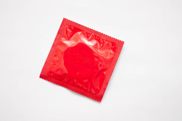 paquet de préservatif rouge sur fond blanc - condom photos et images de collection