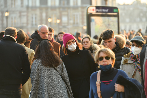 Paris, France-01 15 2022: People wearing protective face masks in a street of Paris, France during the global coronavirus epidemic.