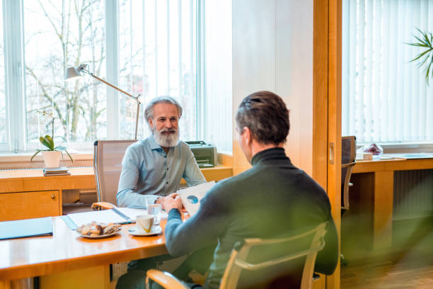 istock Mature Financial Advisor Explaining Graphs to Mature Male Client in an Office 1364912405