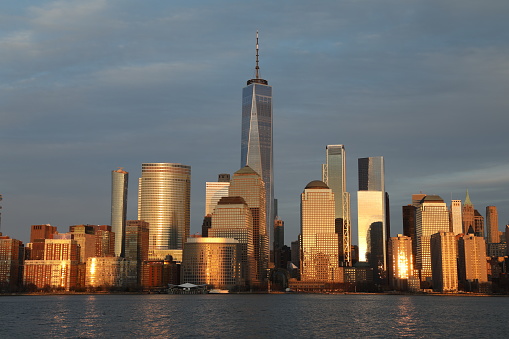 Beautiful view of Manhattan from river. Skyscrapers on background of sky with clouds. New York. USA.