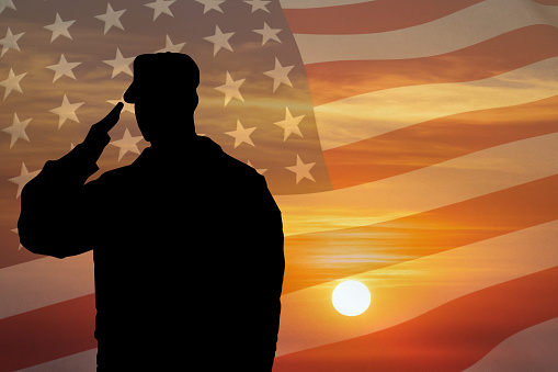 Soldier silhouette saluting gesture at sunset