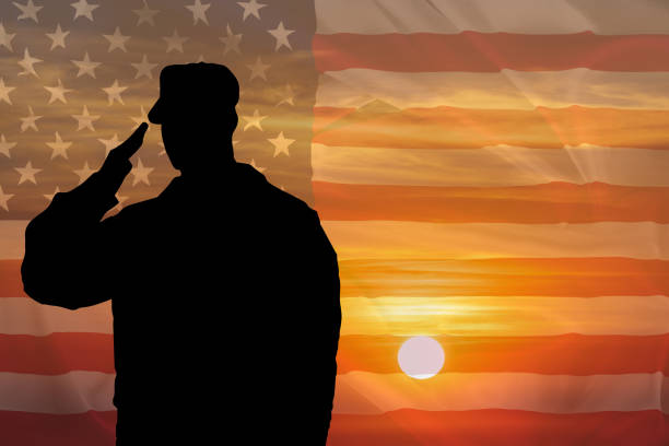 Soldier silhouette saluting gesture at sunset