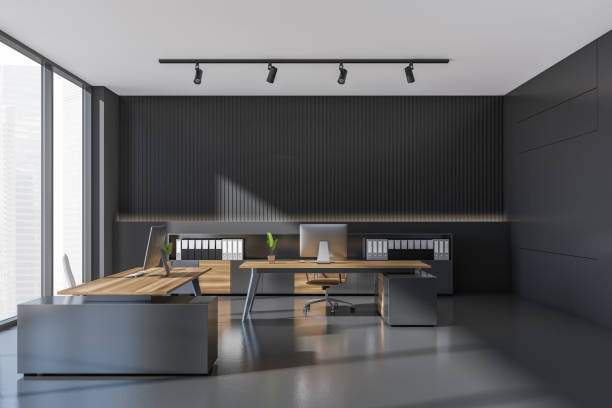 istock Dark office room interior with two desks, comfortable armchairs, desktops 1364914079