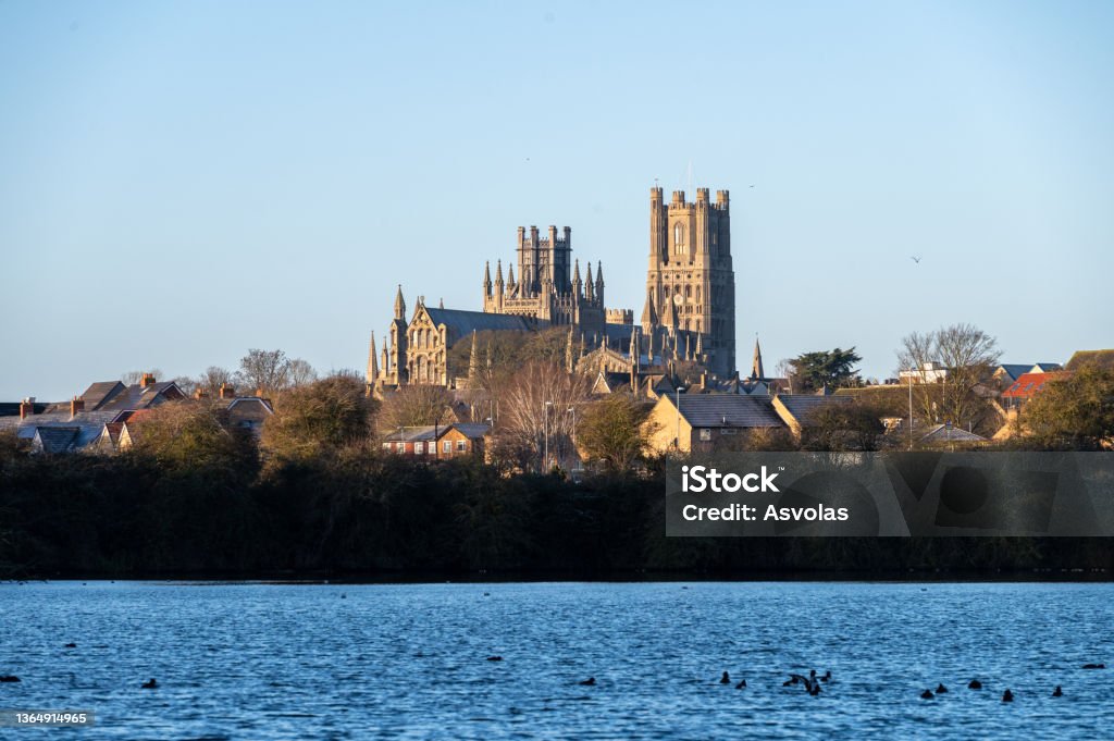 Cathedral of Ely with a lake infront during sunrise The cathedral of Ely with a lake infront during sunrise Autumn Stock Photo