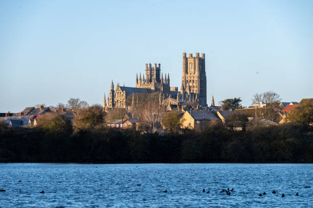 Cathedral of Ely with a lake infront during sunrise The cathedral of Ely with a lake infront during sunrise ely england stock pictures, royalty-free photos & images