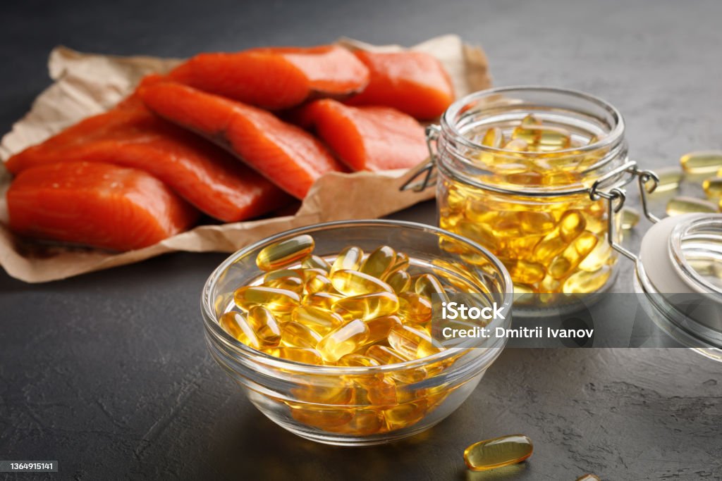 Omega 3 capsules and salmon red fish Vitamin D supplement concept - omega 3 capsules and salmon red fish Fish Oil Stock Photo