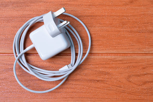 istock Laptop charging plug with USB type-c cable isolated on a wooden background. 1364915615