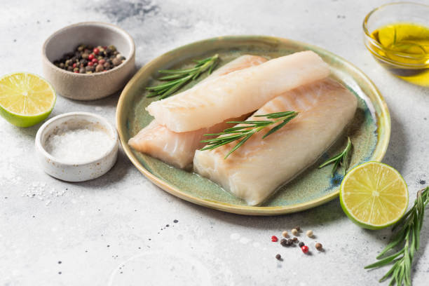ceramic plate with fresh raw cod fish, aromatic herbs - bacalhau imagens e fotografias de stock